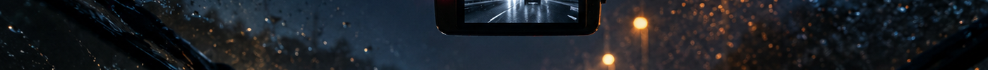 Dashcam met nachtzicht gemonteerd achter de voorruit tijdens een regenachtige nacht